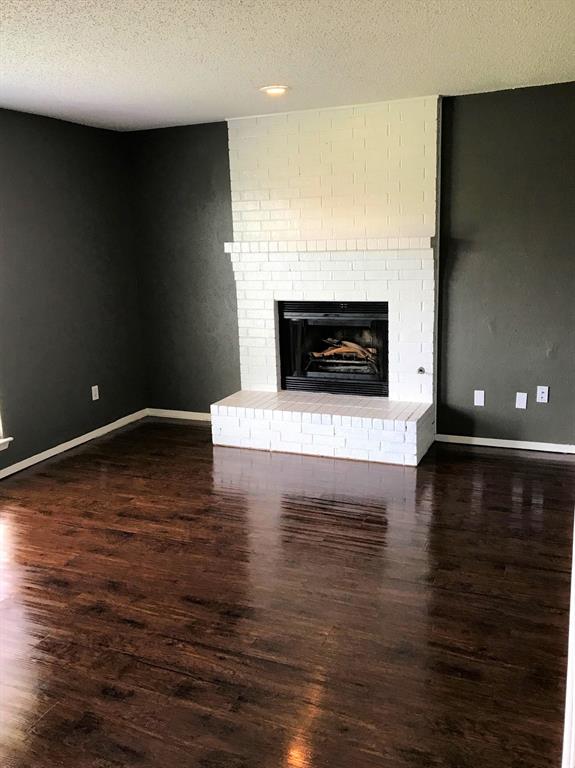 4023 William Street Sachse, TX 75048 - Photo 5 of 36 4023 living room featuring wood style floors and a fireplace