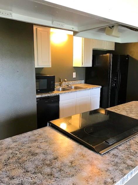 4023 William Street Sachse, TX 75048 - Photo 7 of 36 4023 Kitchen with black appliances, white cabinetry, and light stone countertops