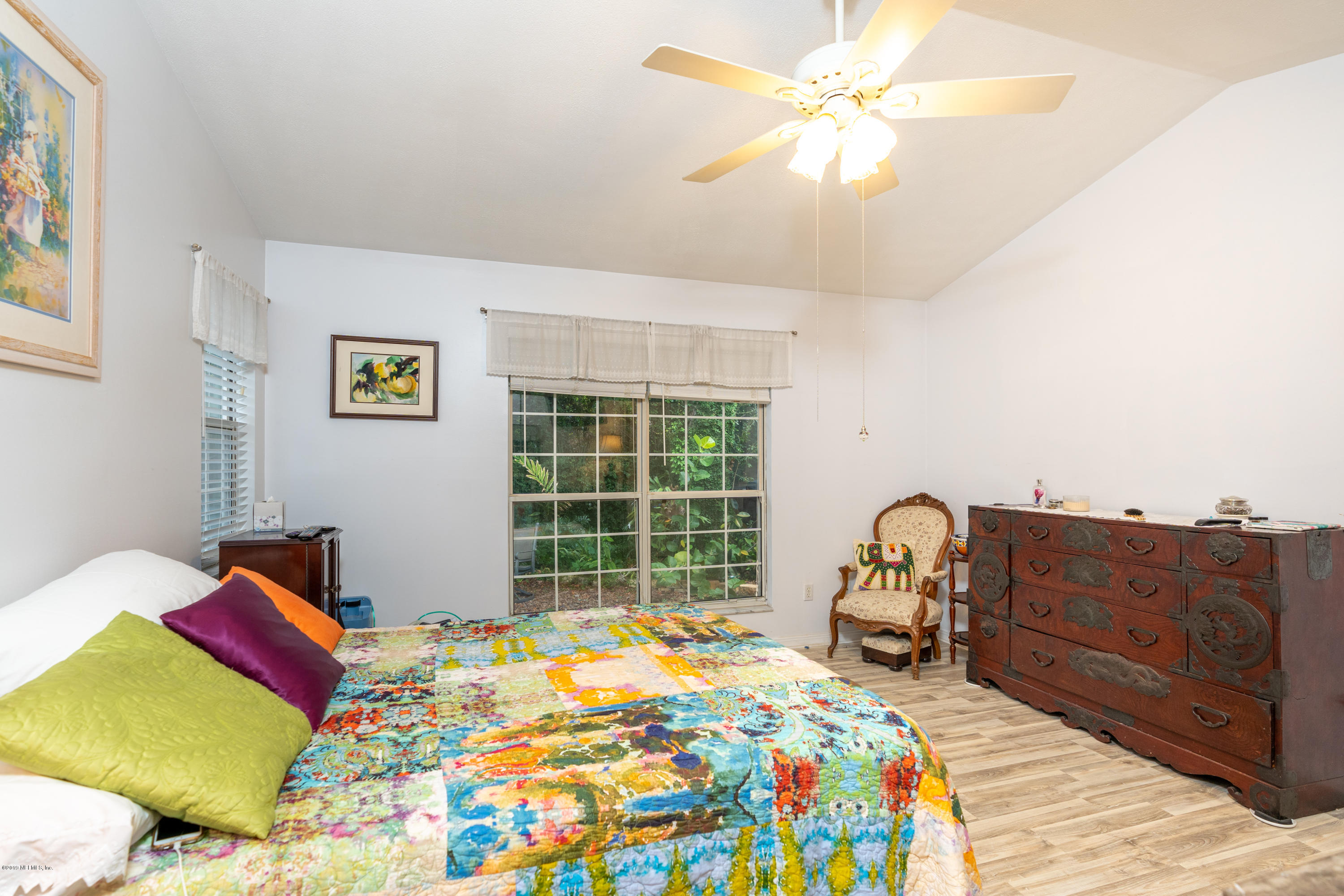 9 Beach Street St. Augustine, FL 32080 - Photo 21 of 28 a bedroom with a bed and a chandelier