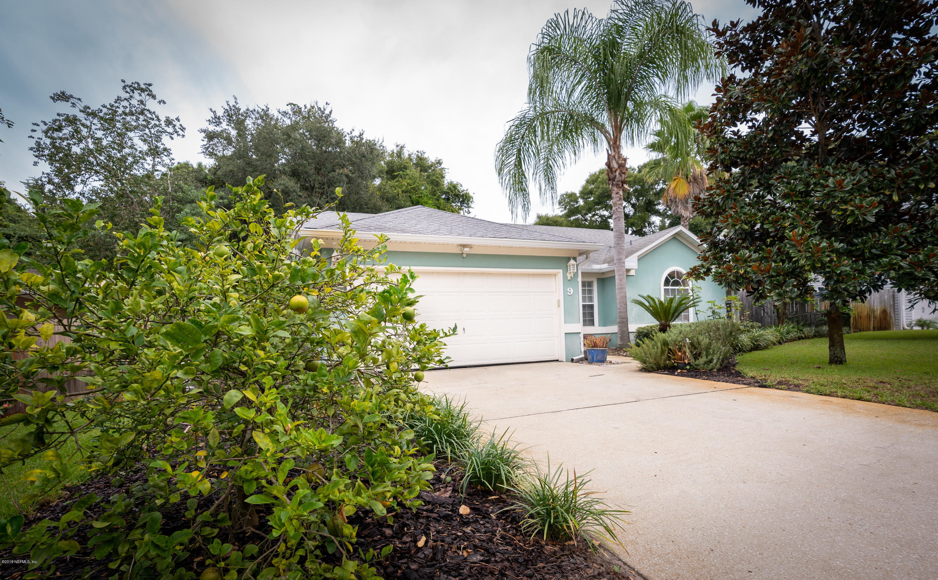 9 Beach Street St. Augustine, FL 32080 - Photo 3 of 28 a front view of a house with a garden and trees