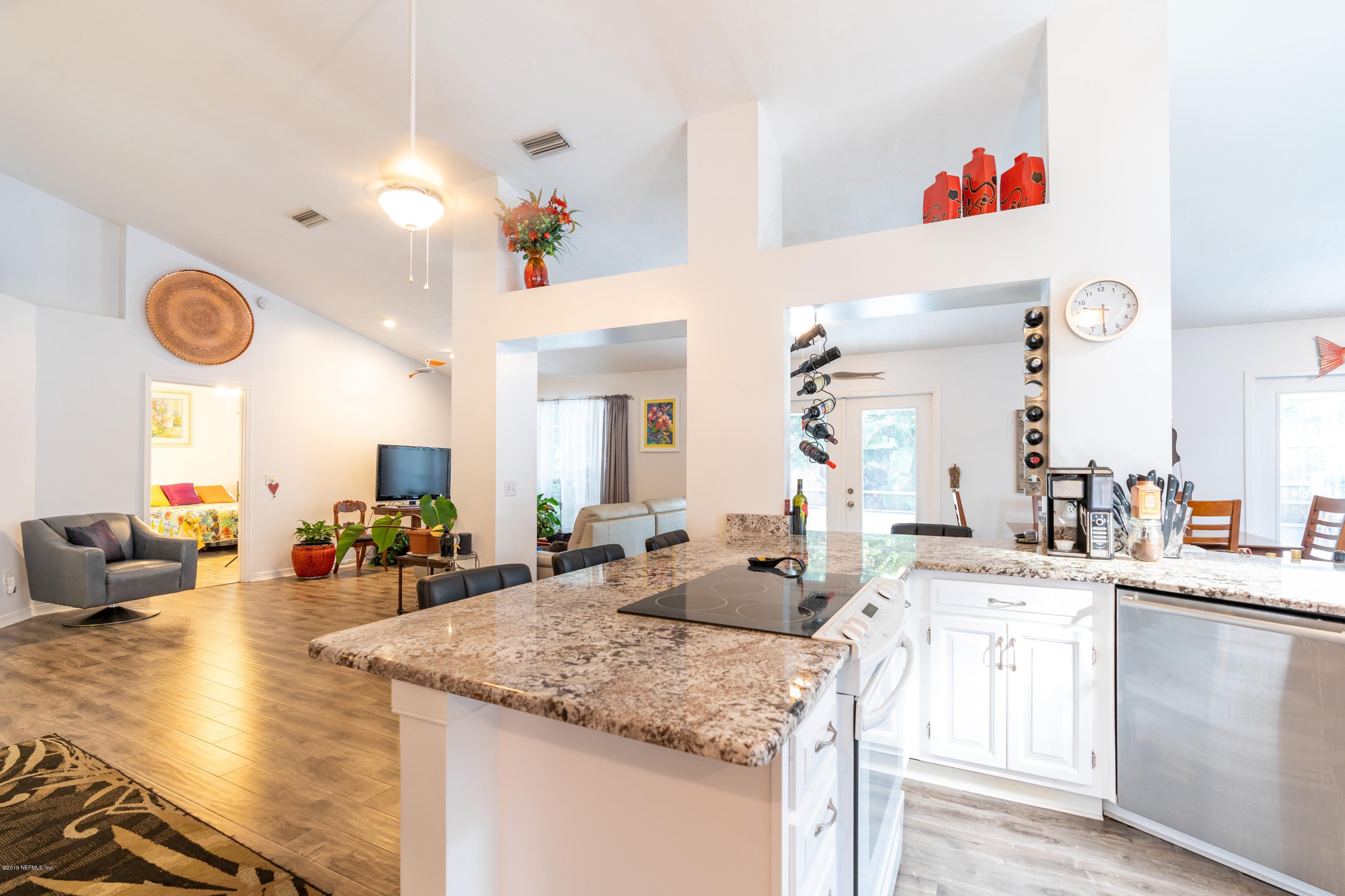 9 Beach Street St. Augustine, FL 32080 - Photo 9 of 28 a kitchen with a sink dishwasher a dining table and chairs with wooden floor