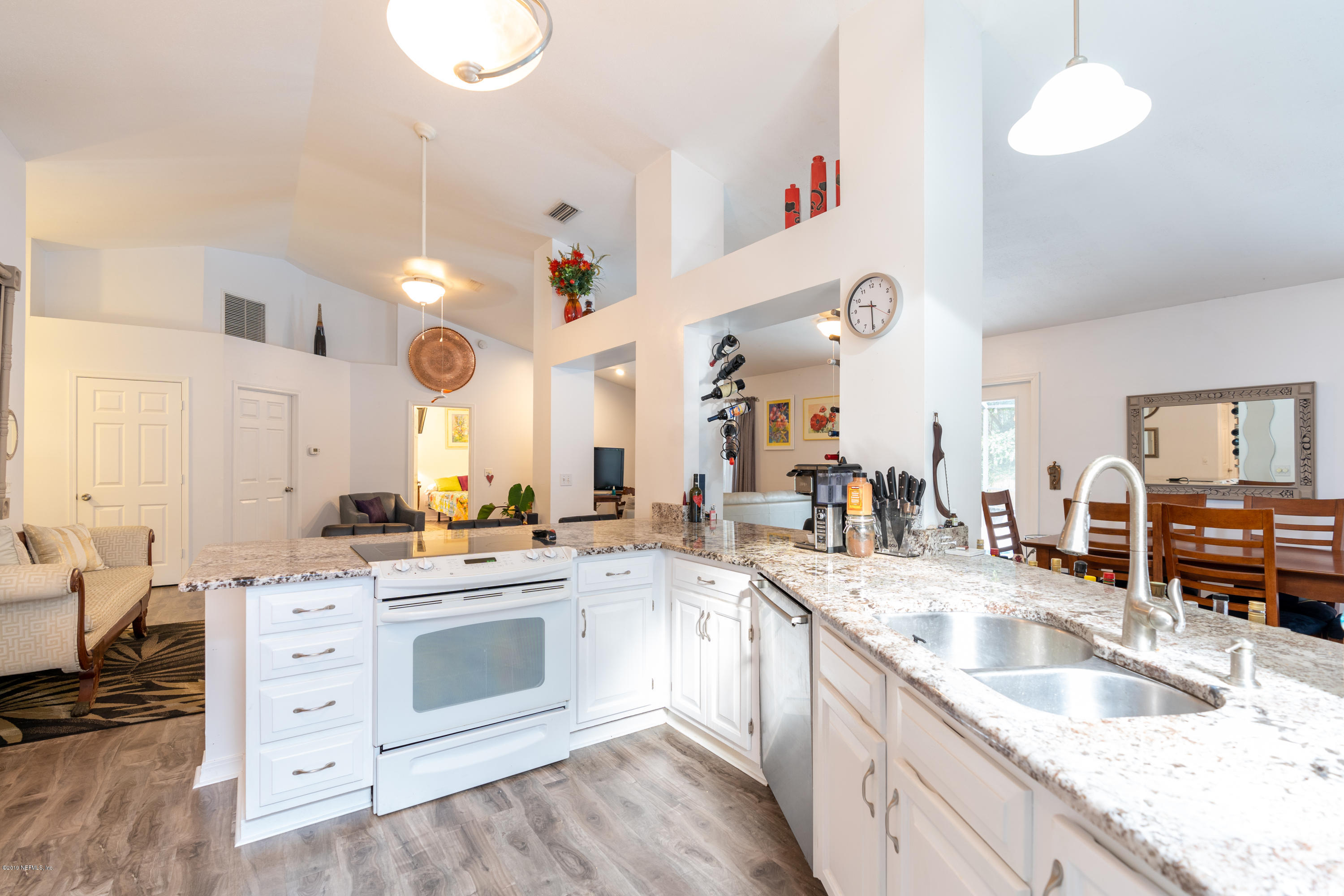 9 Beach Street St. Augustine, FL 32080 - Photo 10 of 28 a kitchen with a sink dishwasher stove and white cabinets with wooden floor