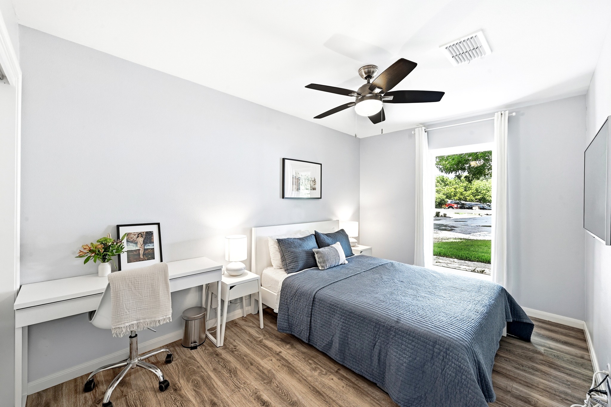 7110 Windrift Way Austin, TX 78745 - Photo 20 of 30 A well-appointed bedroom features robust wood flooring and a refreshing ceiling fan for optimal comfort.
