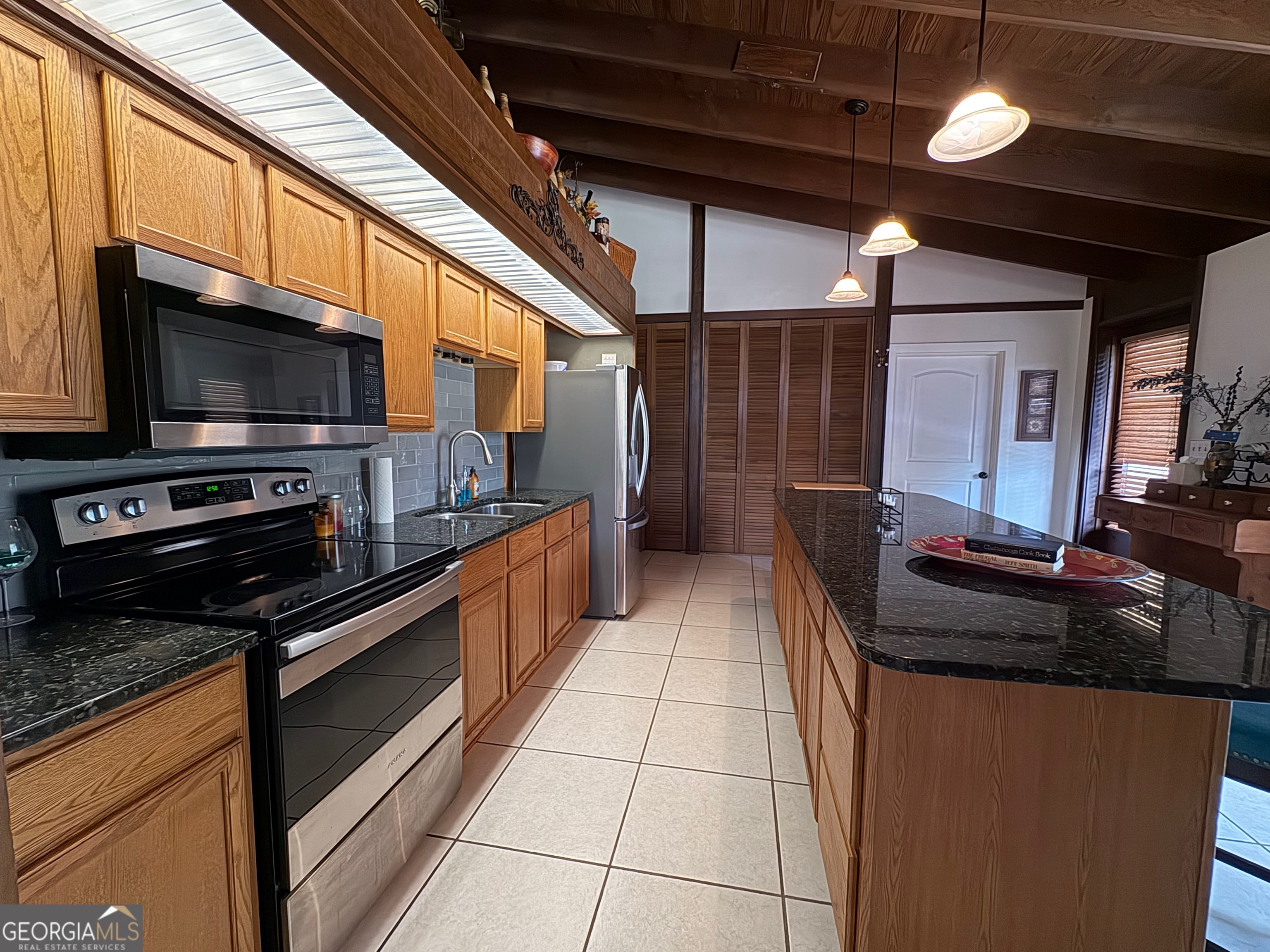 700 Forrest Drive Fort Valley, GA 31030 - Photo 19 of 41 a kitchen with stainless steel appliances granite countertop a stove and a microwave
