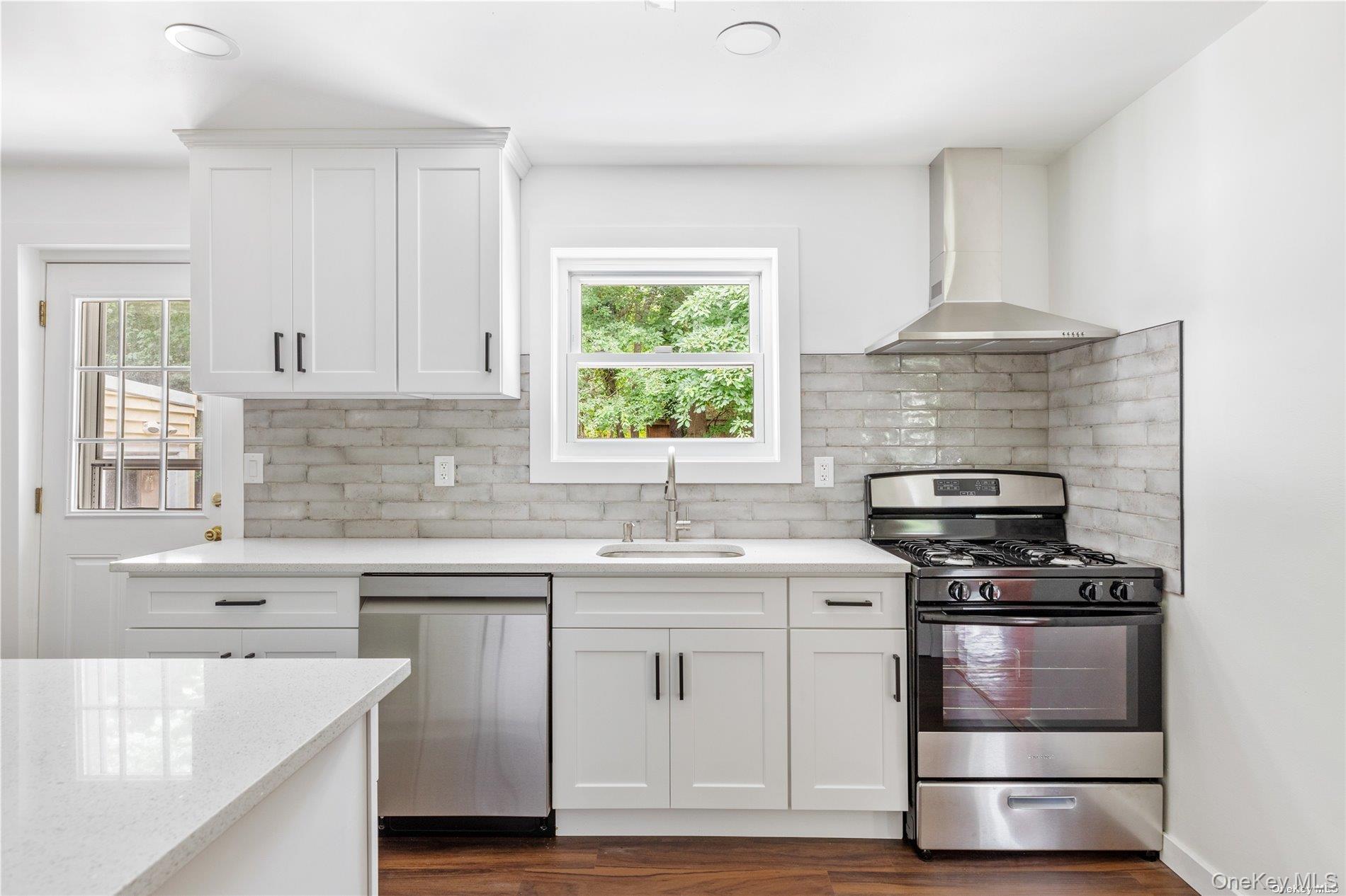 110 East Bartlett Road Middle Island, NY 11953 - Photo 12 of 29 a kitchen with white cabinets and appliances