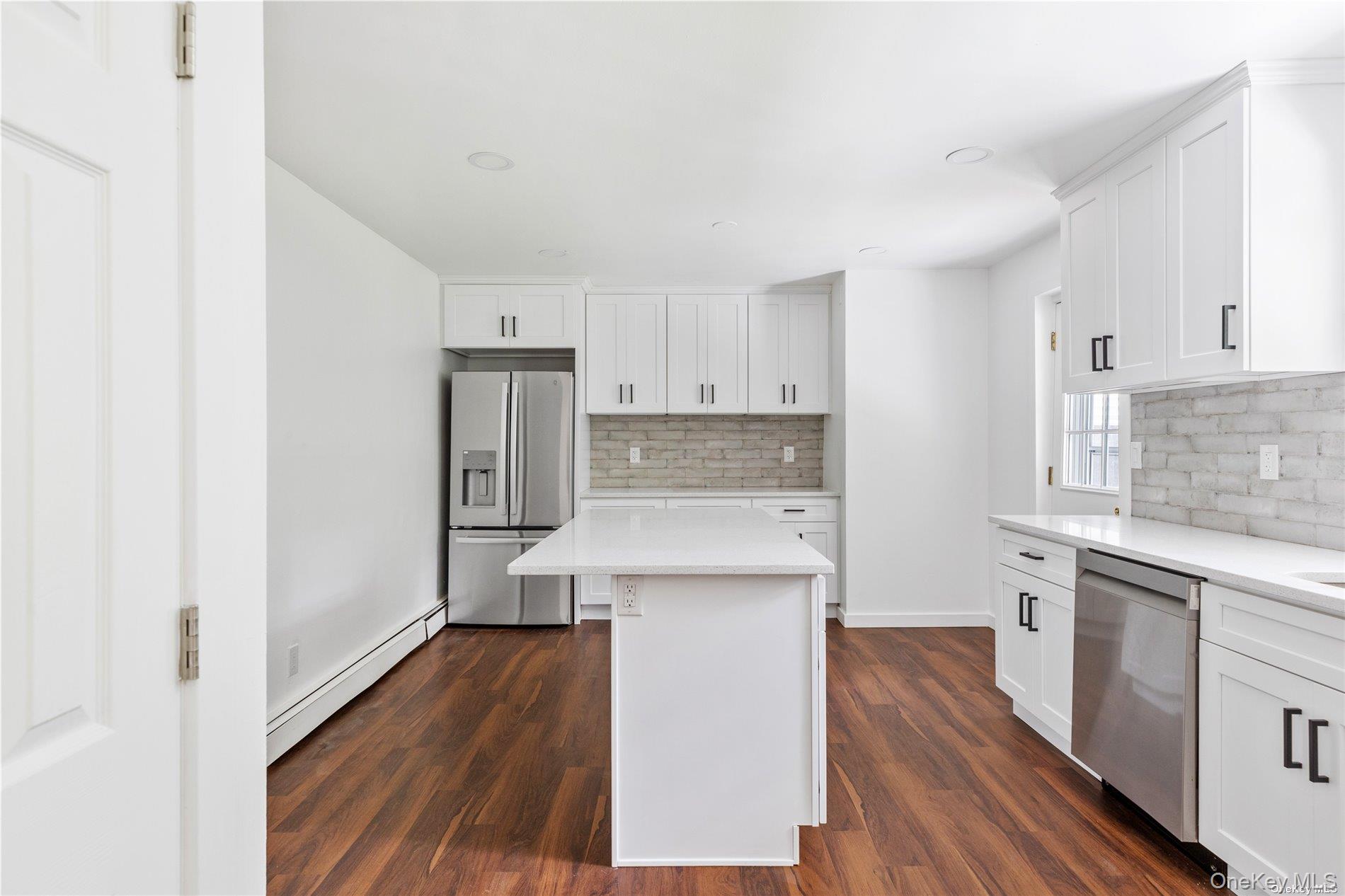 110 East Bartlett Road Middle Island, NY 11953 - Photo 9 of 29 a kitchen with a sink a refrigerator and cabinets