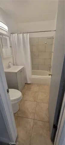 a white toilet sitting next to a bath tub