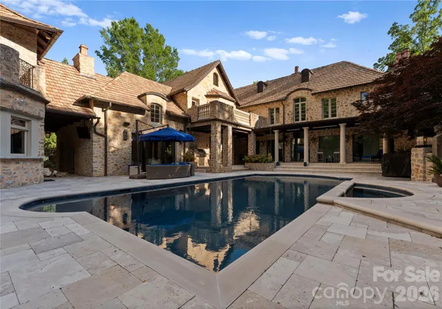 a view of a house with swimming pool and sitting area