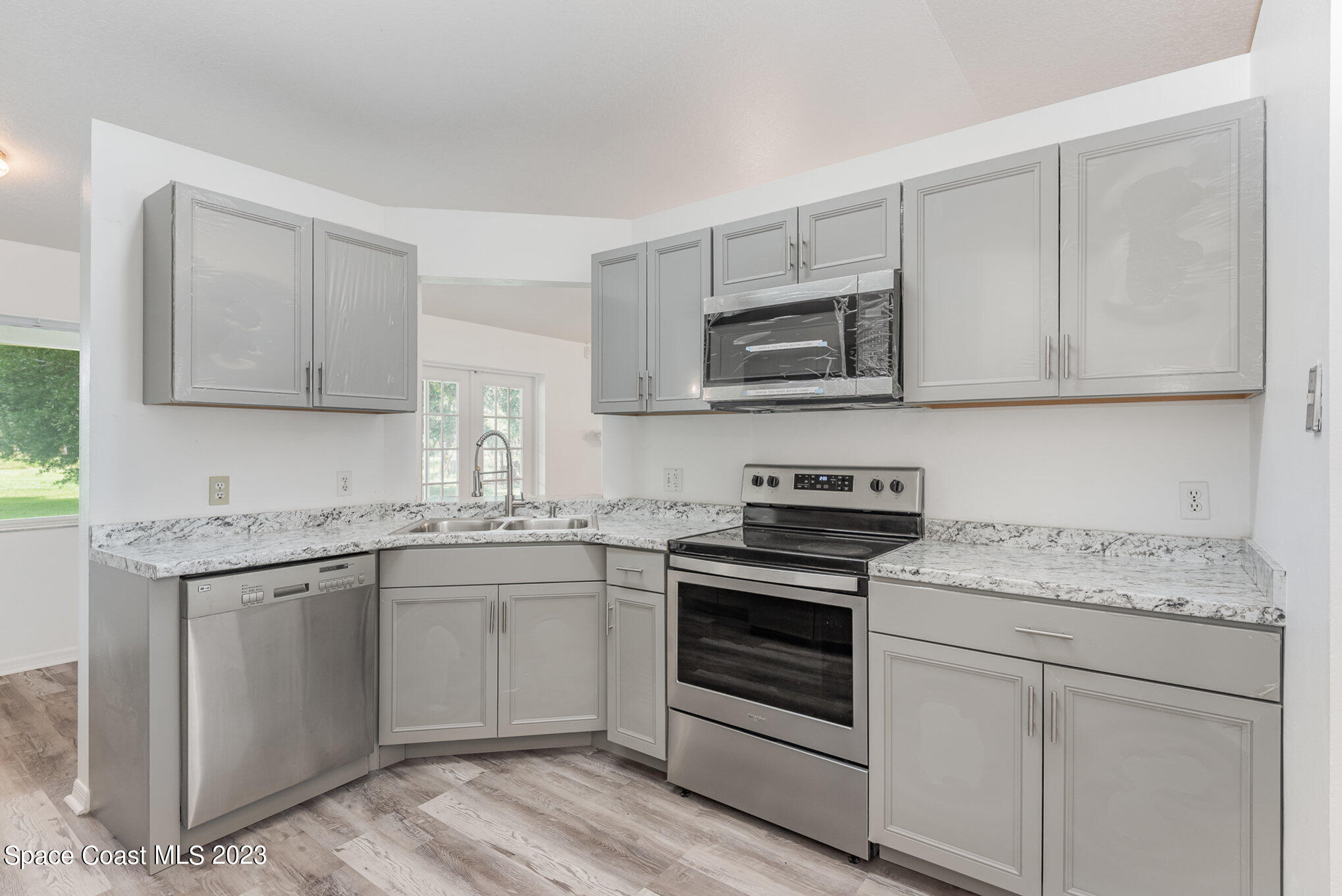 4390 London Town Road Titusville, FL 32796 - Photo 11 of 25 a kitchen with stainless steel appliances granite countertop a stove microwave and cabinets