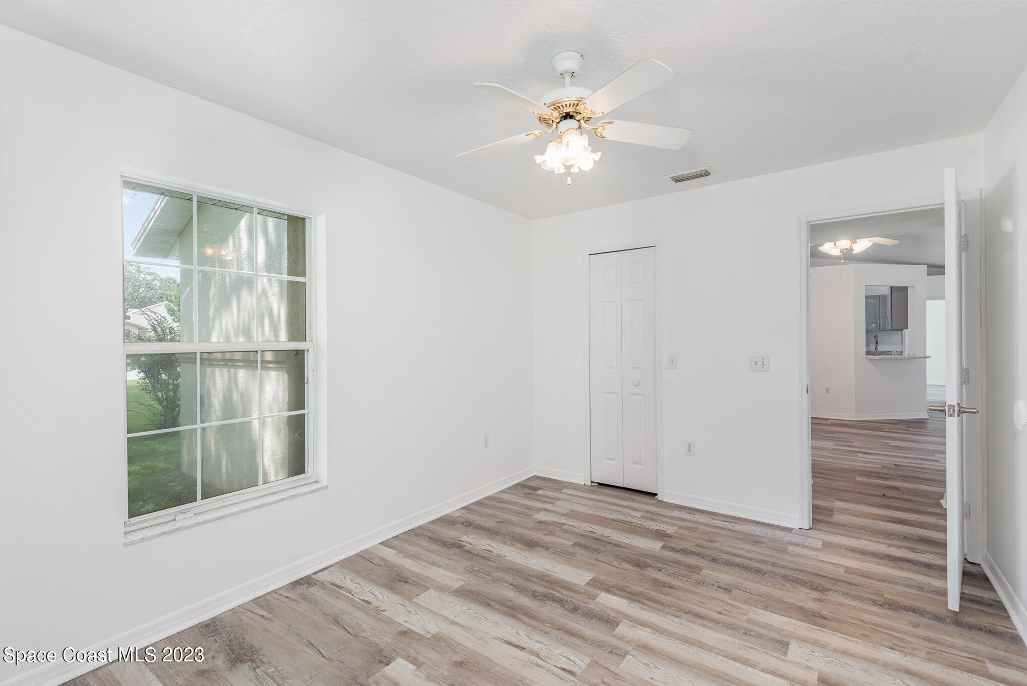4390 London Town Road Titusville, FL 32796 - Photo 13 of 25 a view of an empty room with wooden floor and a window