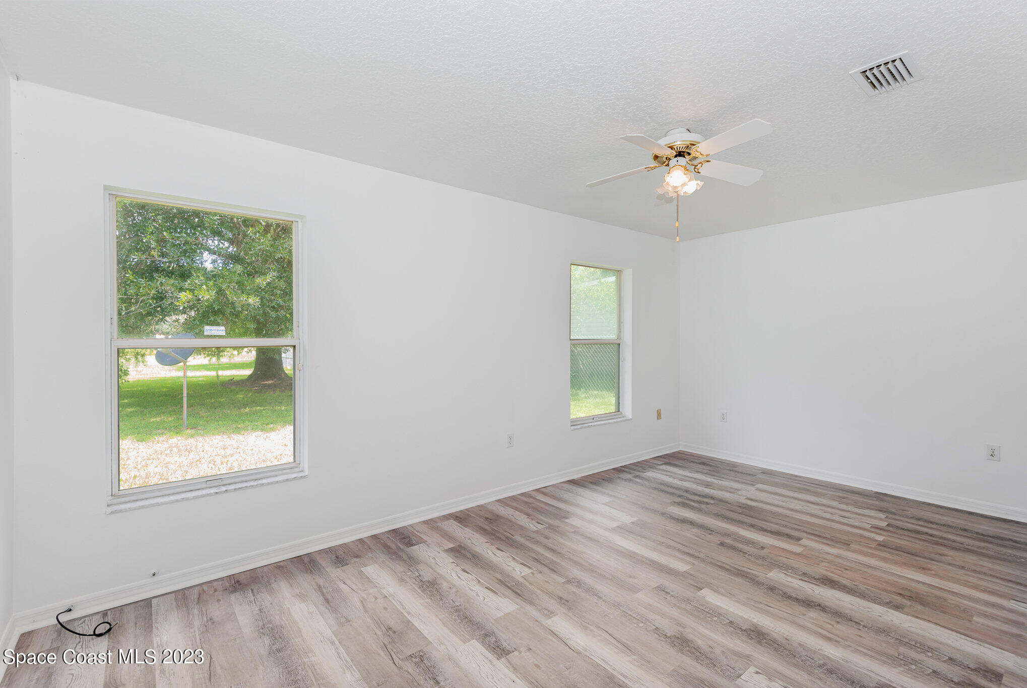 4390 London Town Road Titusville, FL 32796 - Photo 14 of 25 a view of empty room with wooden floor and fan