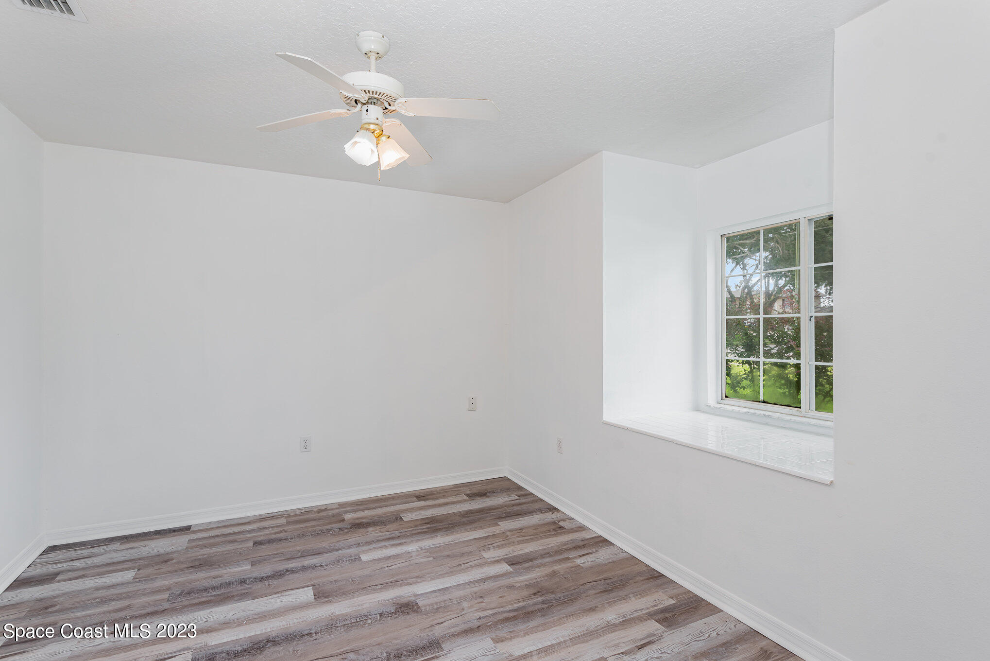 4390 London Town Road Titusville, FL 32796 - Photo 7 of 25 wooden floor in an empty room with a window