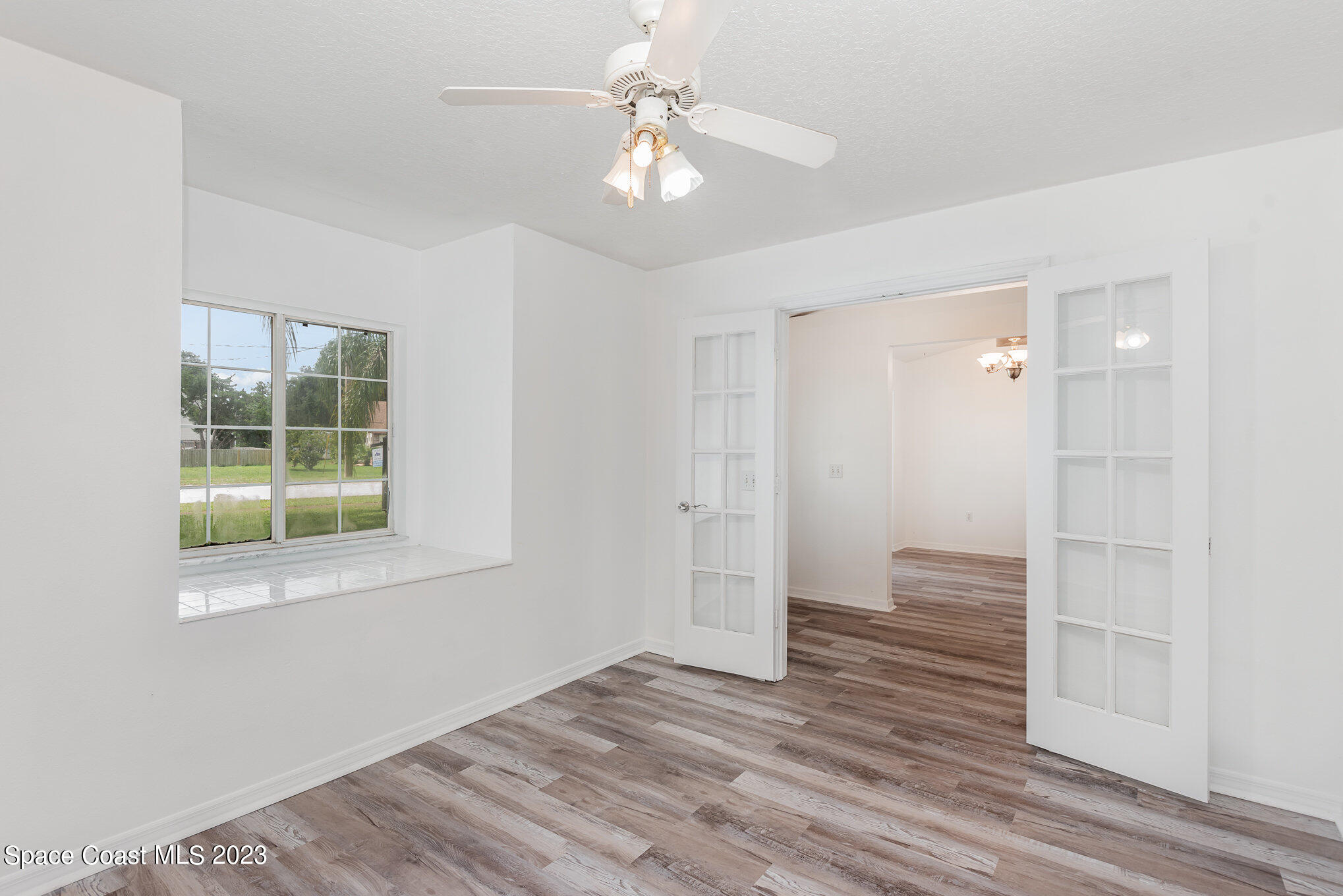 4390 London Town Road Titusville, FL 32796 - Photo 8 of 25 a view of an empty room with wooden floor and a window
