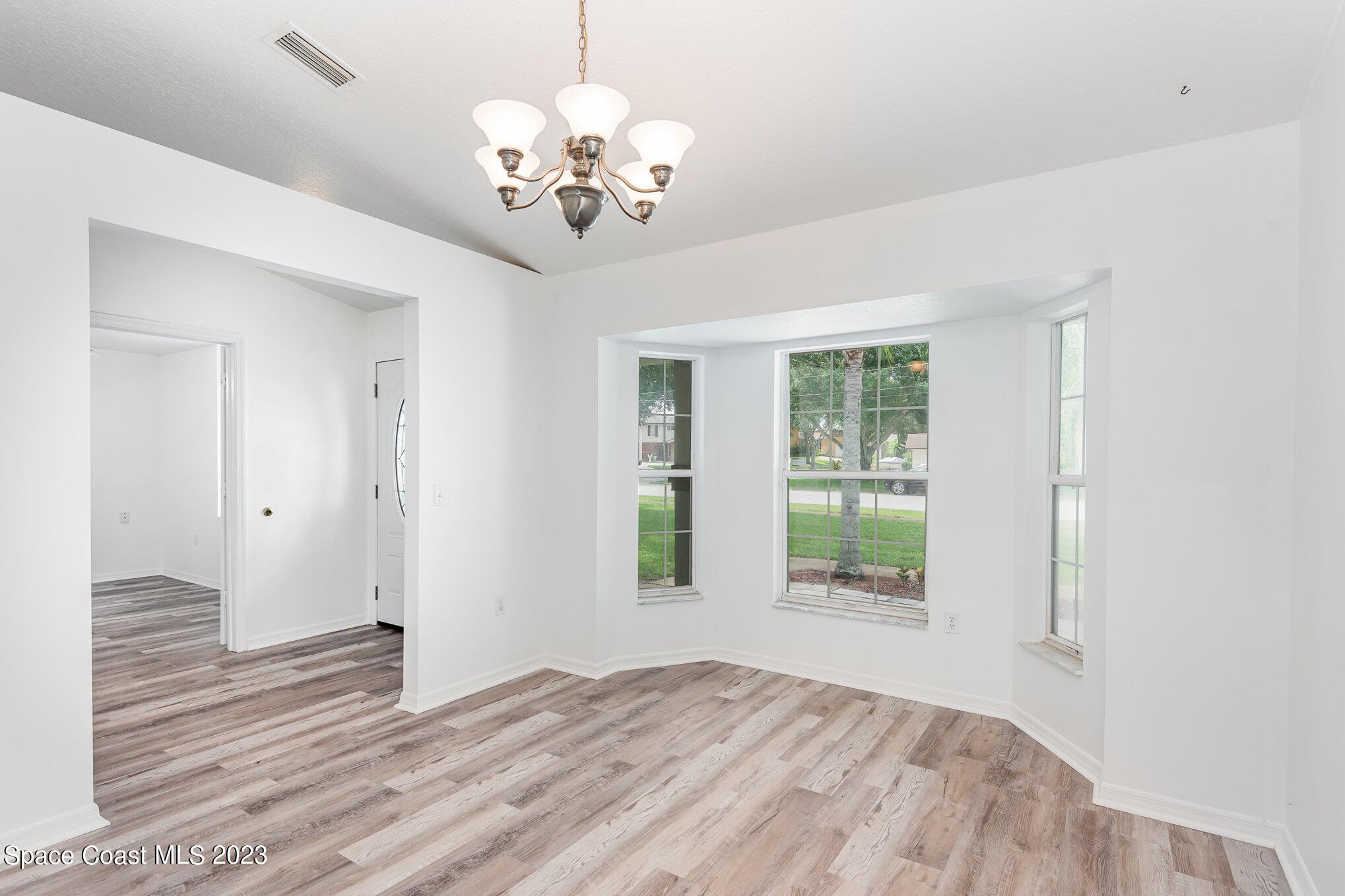 4390 London Town Road Titusville, FL 32796 - Photo 10 of 25 a view of a bedroom with wooden floor and chandelier