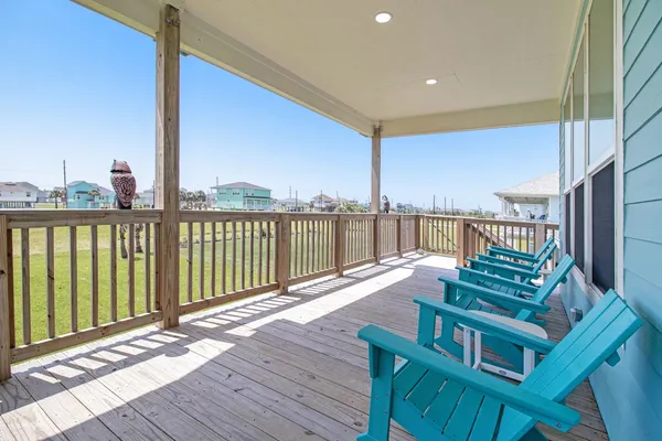 a view of a balcony with wooden floor next to a yard