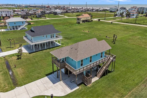 an aerial view of a house with a garden and lake view