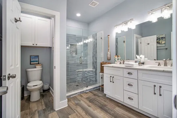 a bathroom with a double vanity sink toilet and shower