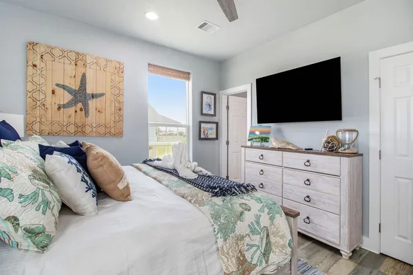 a bedroom with a large bed and a flat screen tv