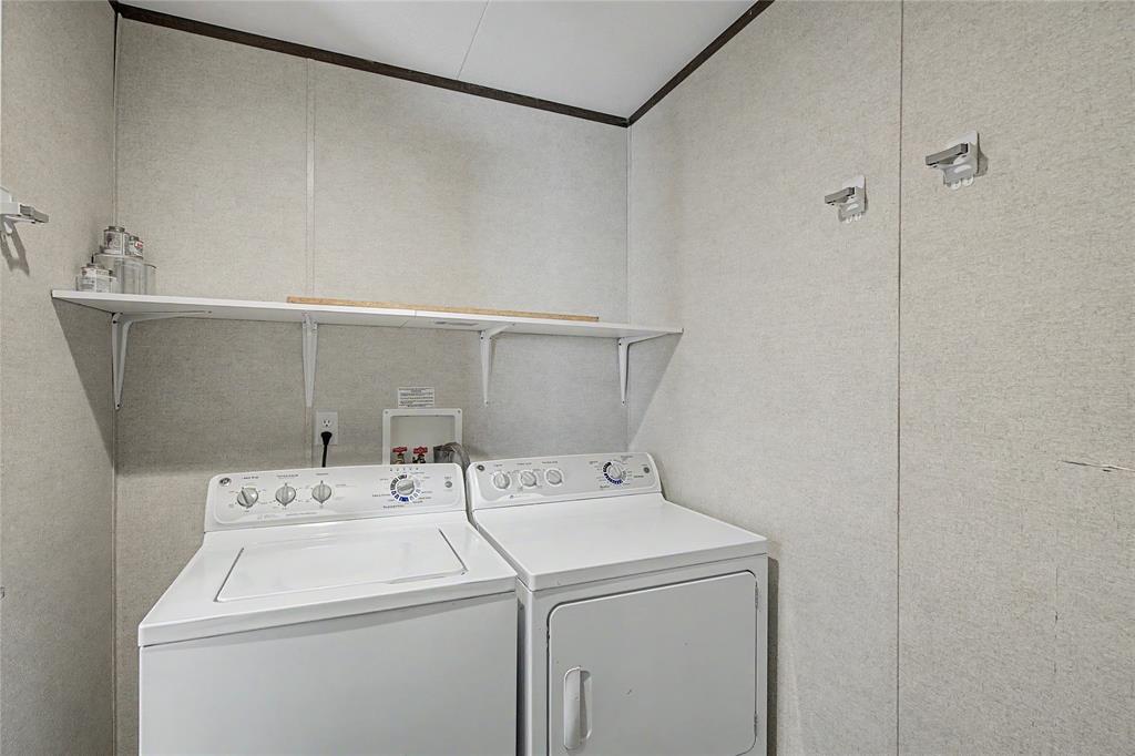177 New Highland Road Springtown, TX 76082 - Photo 19 of 40 Dedicated laundry space featuring white shelving, light-toned wall panels, and dark trim