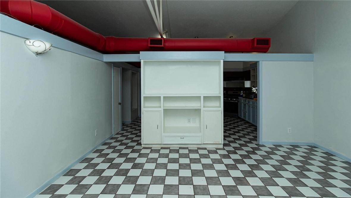 103 South Ave D Bishop, TX 78343 - Photo 4 of 11 a room with a black white checkered floor with a red cabinet