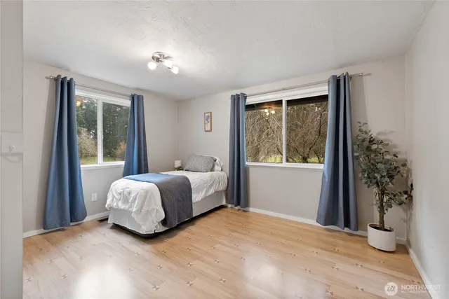 a bedroom with a bed and a large window