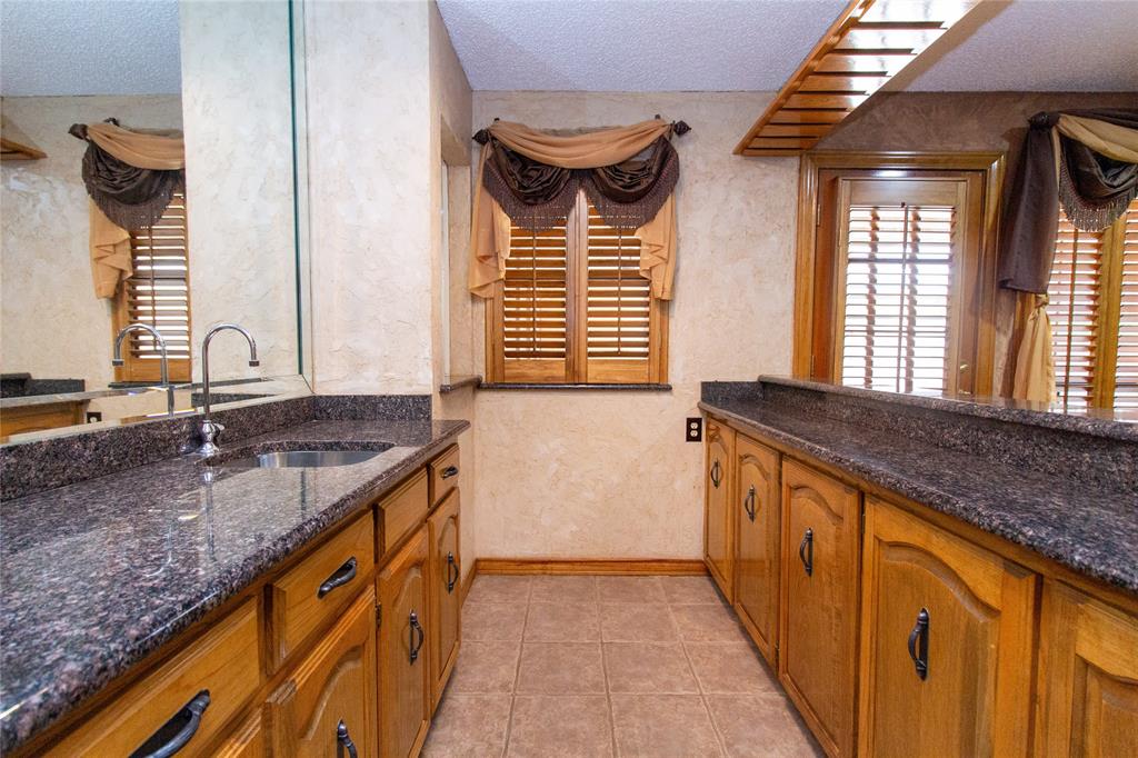 3014 Pecan Ridge Drive Rowlett, TX 75088 - Photo 22 of 29 a bathroom with a granite countertop sink and a mirror
