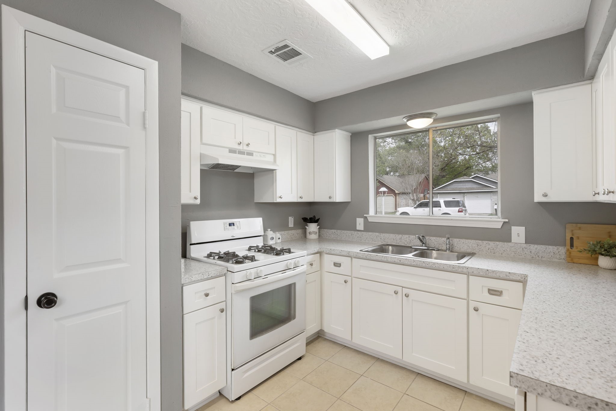 29107 Binefield Street Spring, TX 77386 - Photo 5 of 18 Recently remodeled and FULL OF FUNCTION! Bright kitchen with soft-close cabinetry, updated hardware, new dishwasher and vent hood, generous counter space, stainless steel double-basin sink, large front-facing window, and dedicated pantry!