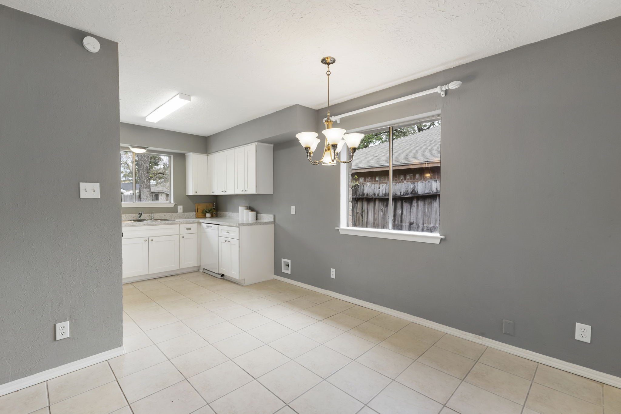 29107 Binefield Street Spring, TX 77386 - Photo 7 of 18 Light-filled dining space with OPEN flow to the kitchen and family room—perfect for everyday living. Decorative light fixture, tile flooring, and large window bring in wonderful natural light.