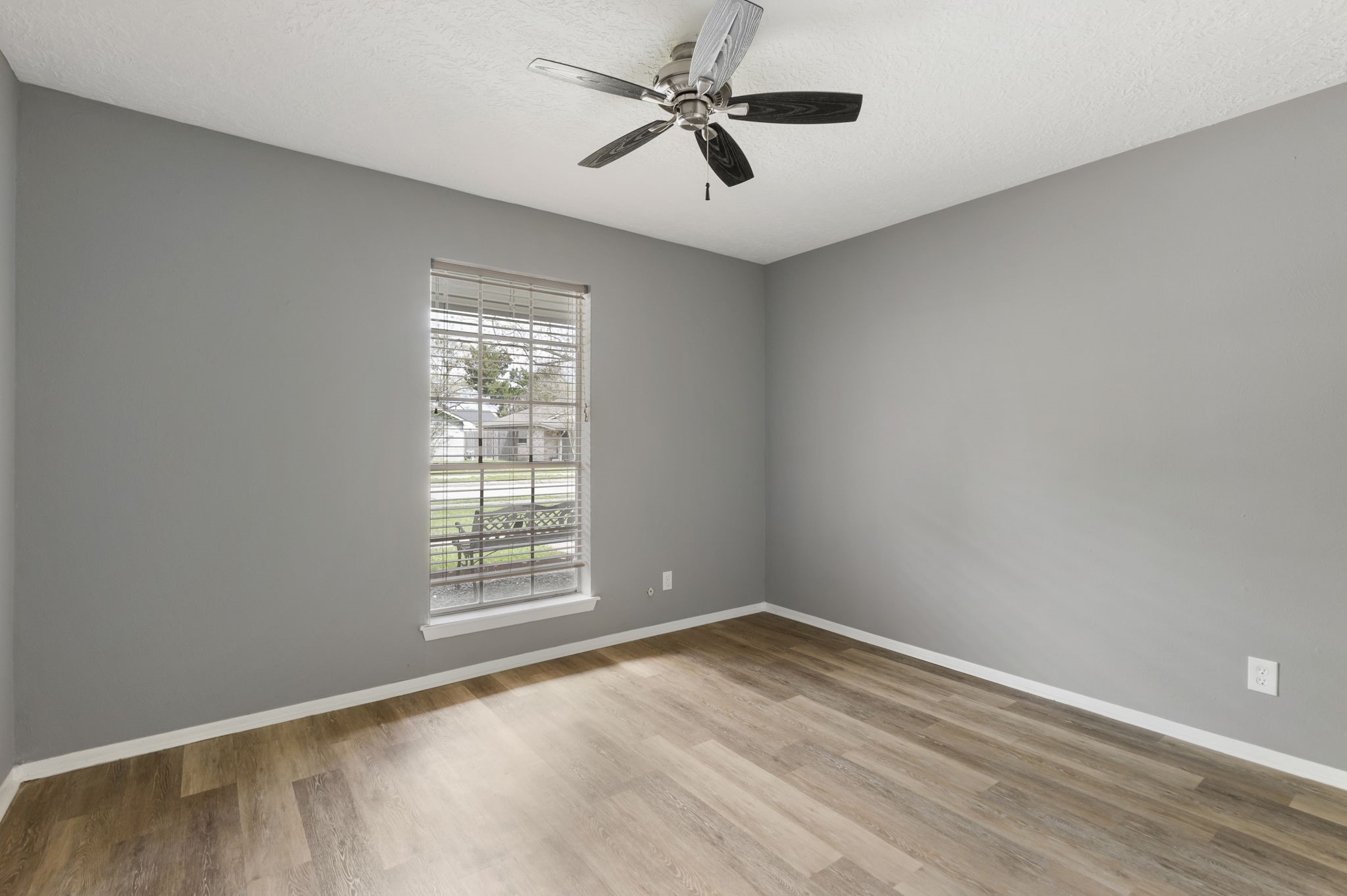 29107 Binefield Street Spring, TX 77386 - Photo 8 of 18 Comfortable secondary bedroom with updated LVP flooring, ceiling fan, and large window.