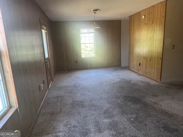 an empty room with windows and closet