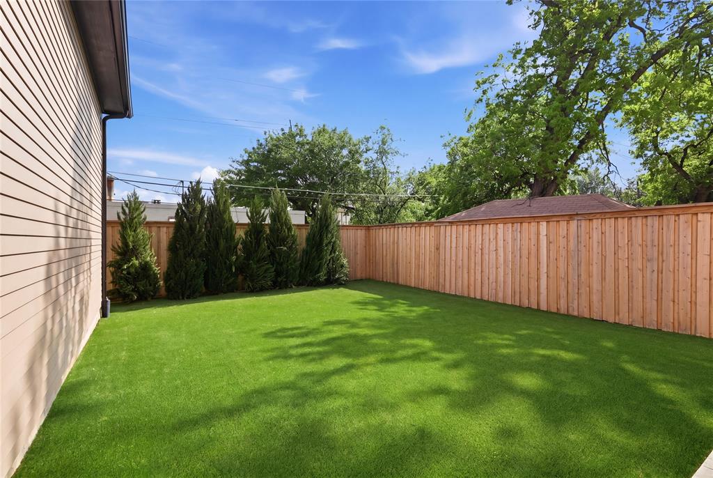 6038 Prospect Avenue Dallas, TX 75206 - Photo 40 of 40 Expansive backyard featuring artificial turf, a new wood privacy fence, and mature evergreen trees