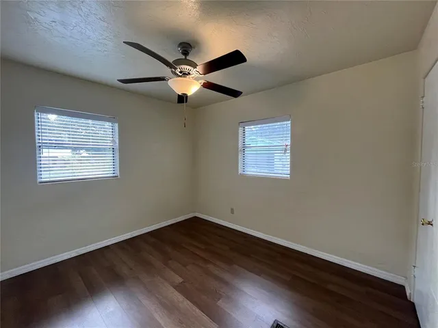 a view of empty room with wooden floor