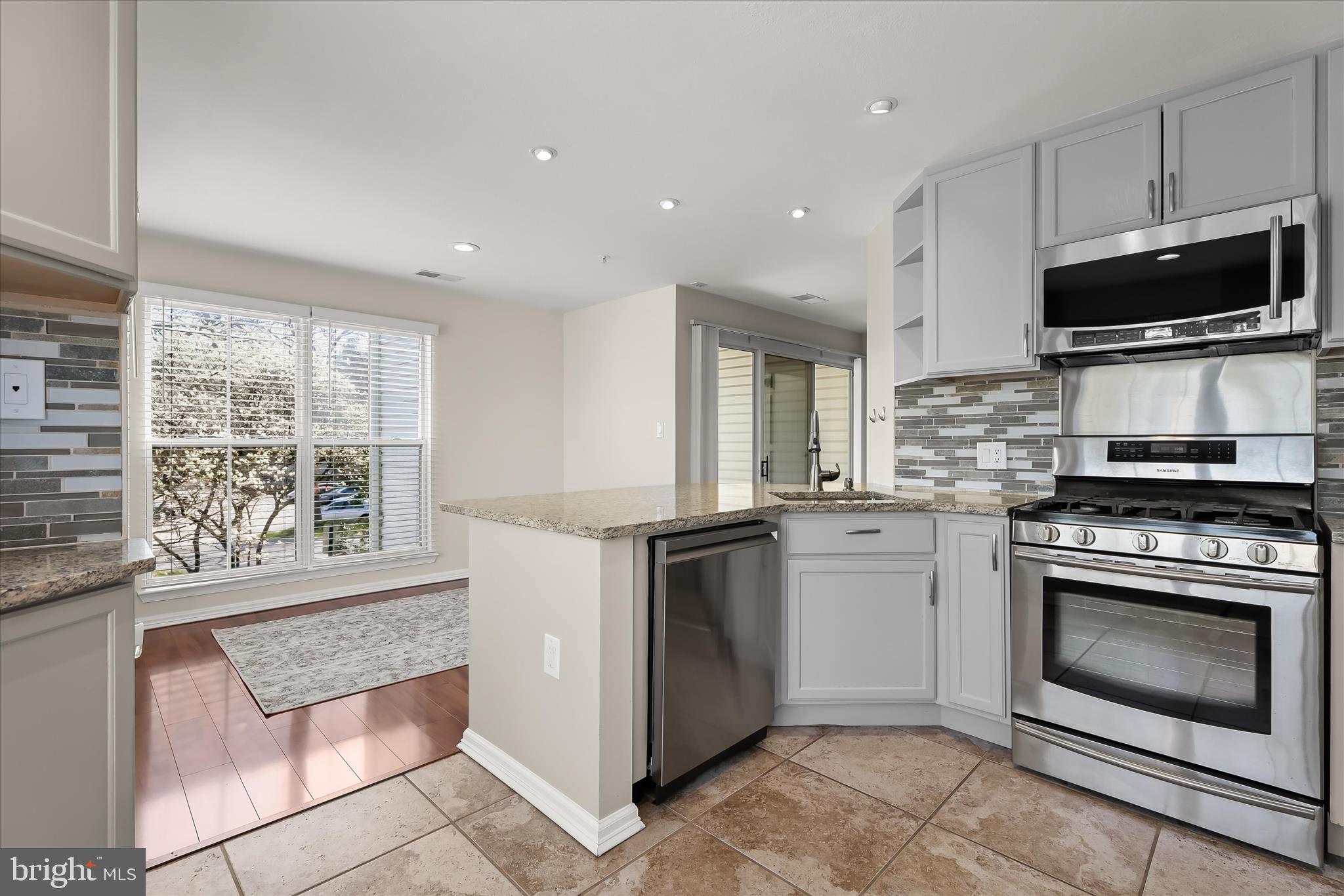 3555 Floating Leaf Lane, Unit C201 Laurel, MD 20724 - Photo 13 of 37 a kitchen with stainless steel appliances granite countertop a stove a microwave and a sink