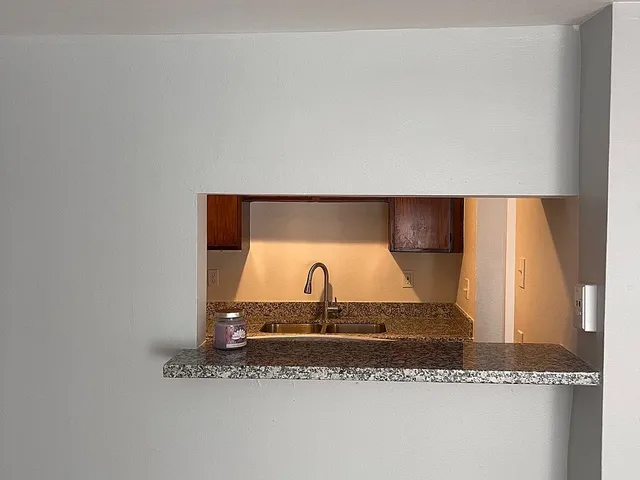 a bathroom with a granite countertop sink and a mirror