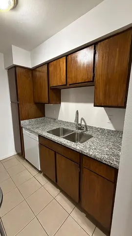 a kitchen with granite countertop sink and cabinets
