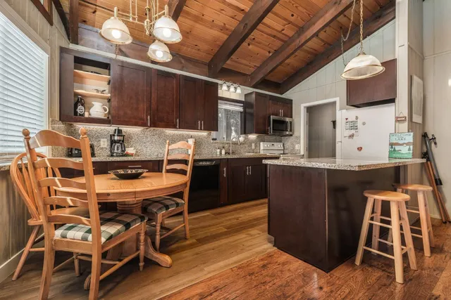 a kitchen with granite countertop a stove a sink and a microwave