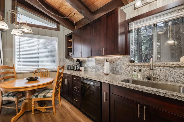 a kitchen with granite countertop a sink and wooden cabinets