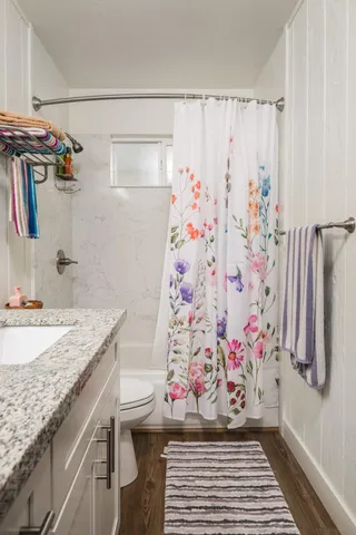 a bathroom with a granite countertop sink and a shower curtain