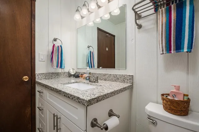 a bathroom with a granite countertop sink and a mirror