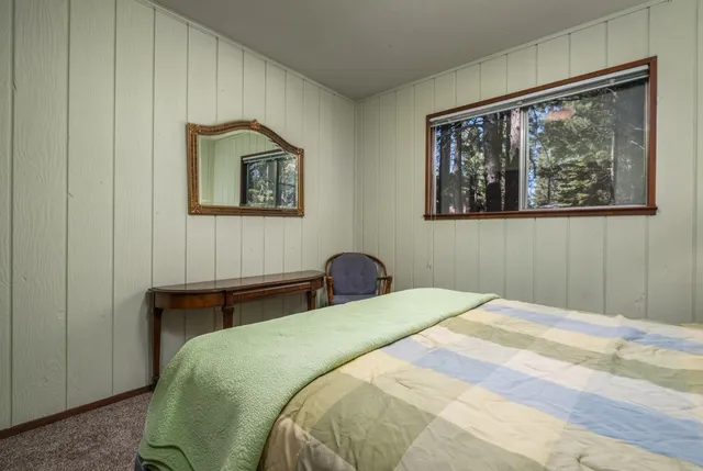 a bedroom with a bed and a painting on the wall