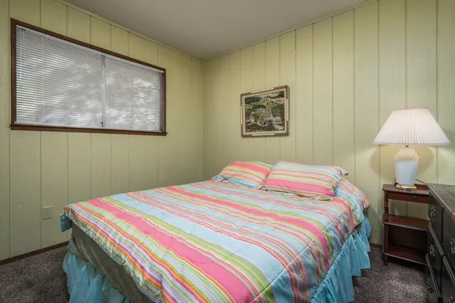 a bedroom with a bed and a wall painting