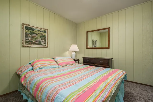 a bedroom with a bed and a painting on the wall