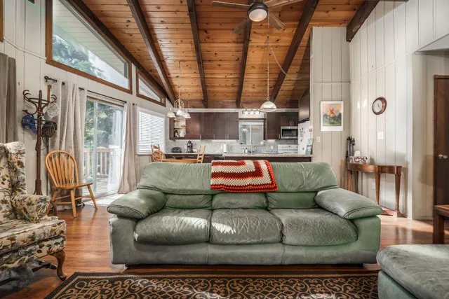 a living room with furniture a couch and large windows