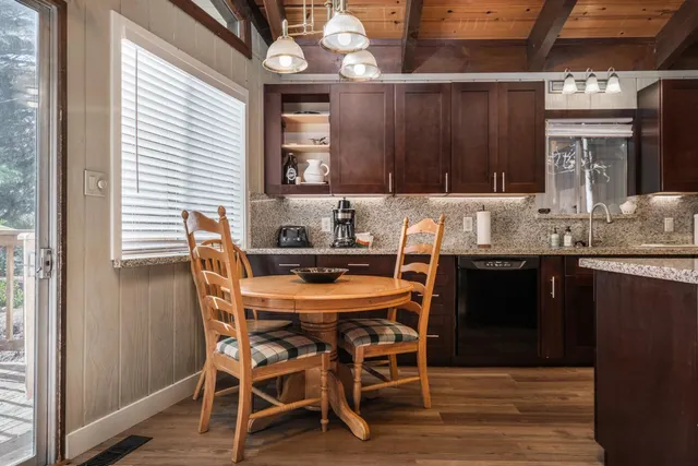 a kitchen with granite countertop a sink dining table and chairs