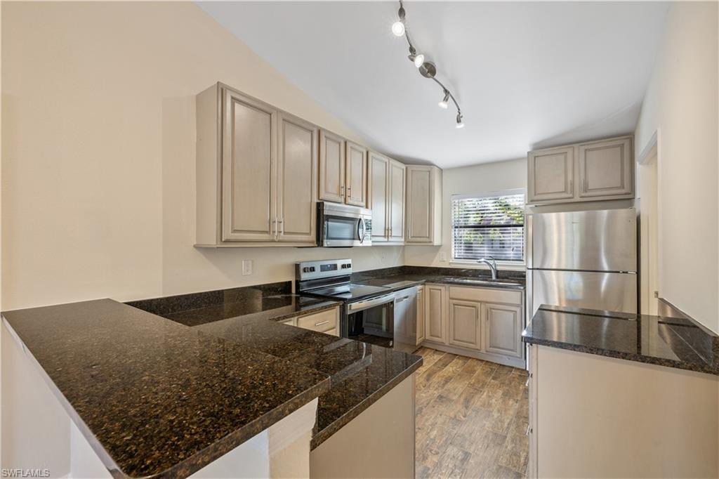 2142 Arbour Walk Circle, Unit 2626 Naples, FL 34109 - Photo 4 of 20 a kitchen with stainless steel appliances granite countertop a sink stove and refrigerator