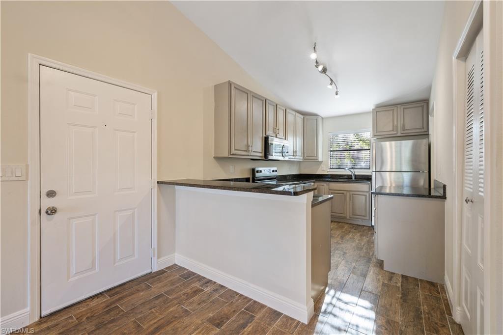 2142 Arbour Walk Circle, Unit 2626 Naples, FL 34109 - Photo 6 of 20 a kitchen with a refrigerator and white cabinets