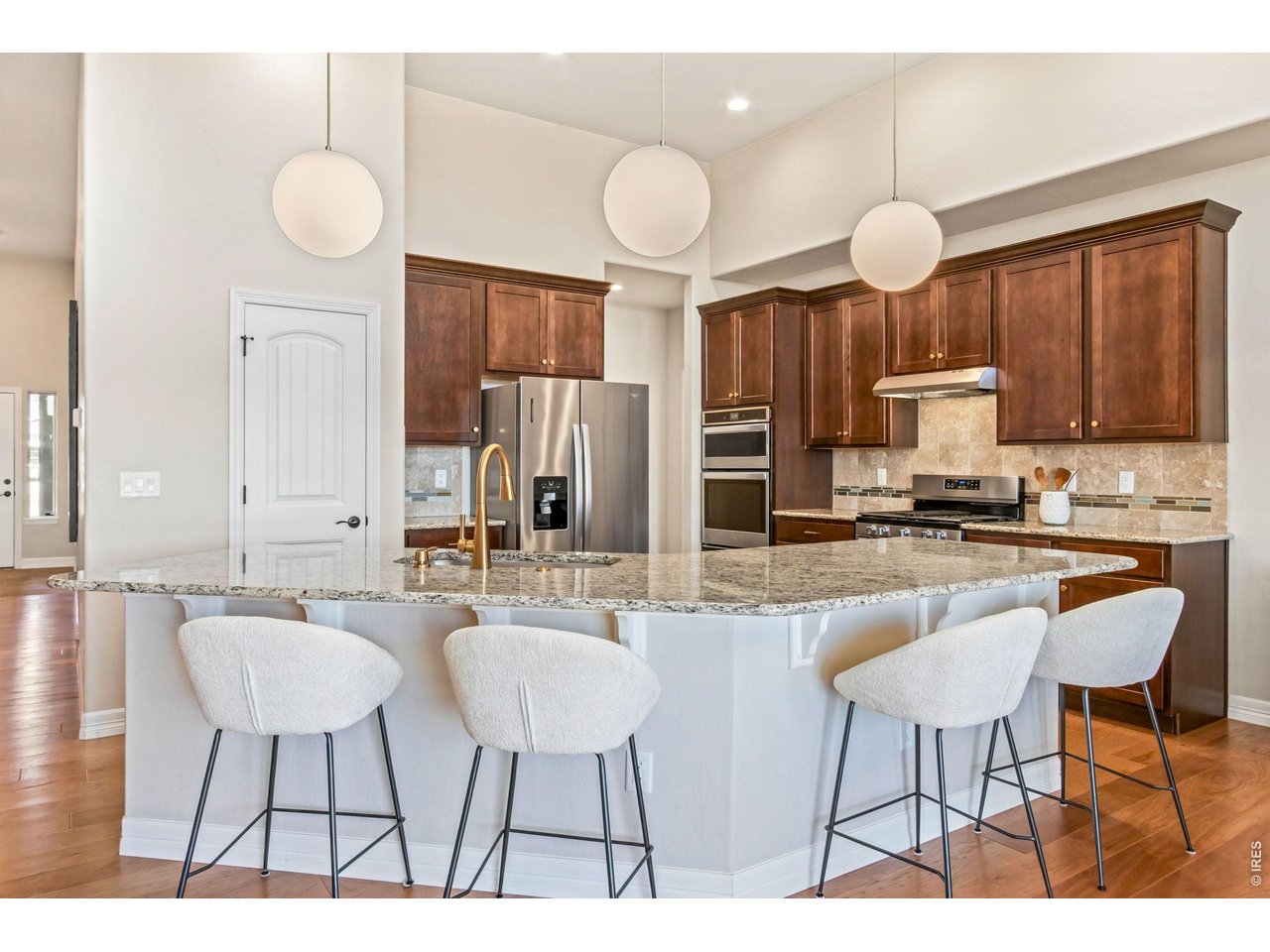 5531 Teeling Court Timnath, CO 80547 - Photo 13 of 48 a kitchen with stainless steel appliances kitchen island granite countertop a dining table chairs and a refrigerator
