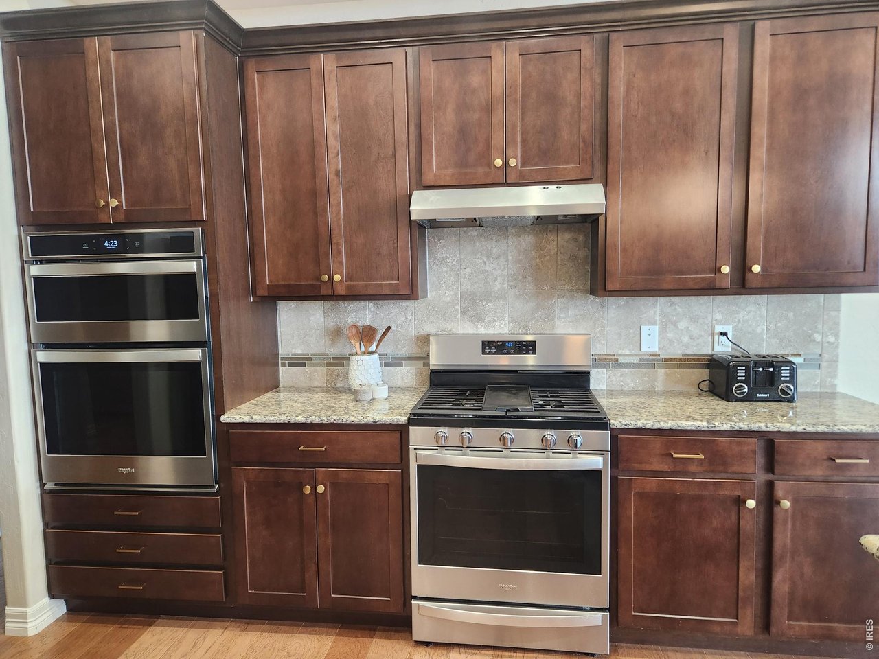 5531 Teeling Court Timnath, CO 80547 - Photo 14 of 48 a kitchen with granite countertop wooden cabinets and stainless steel appliances