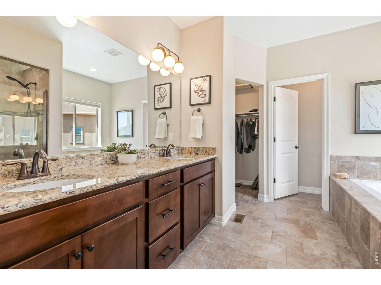 5531 Teeling Court Timnath, CO 80547 - Photo 23 of 48 a spacious bathroom with a granite countertop sink mirror and shower