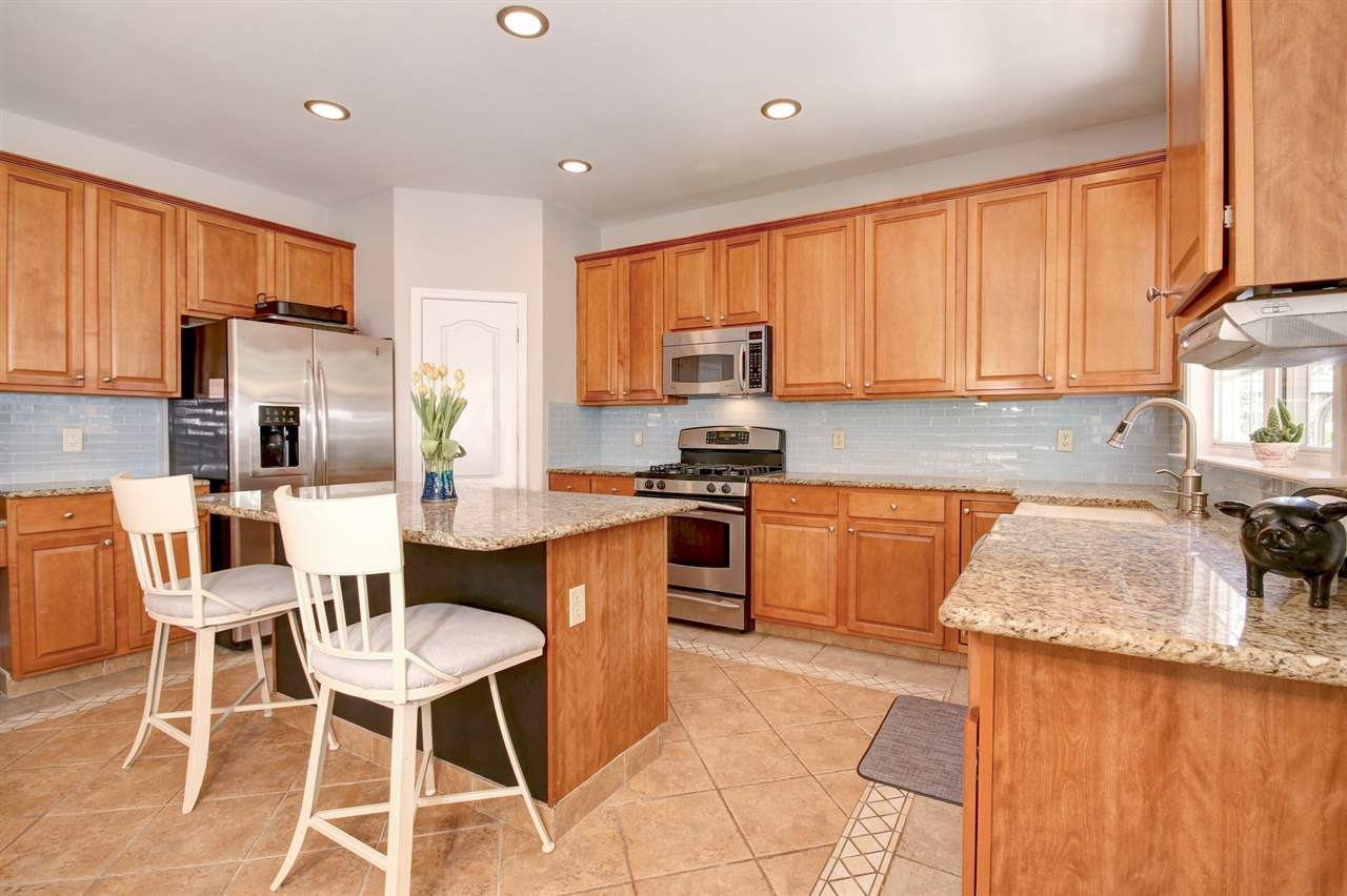 7532 Silver View Lane Raleigh, NC 27613 - Photo 9 of 30 All the bells & whistles in this kitchen! Granite, SS apps, island, w/I pantry, gas range & tile floors + gorgeous backsplash. Kitchen
